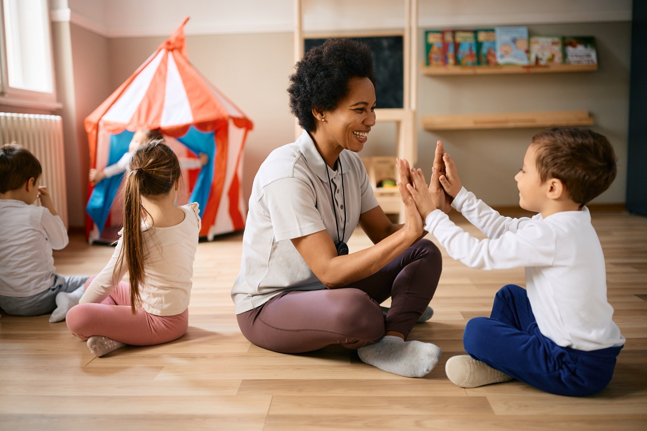 Caregiver interacting with children in a bright, welcoming space