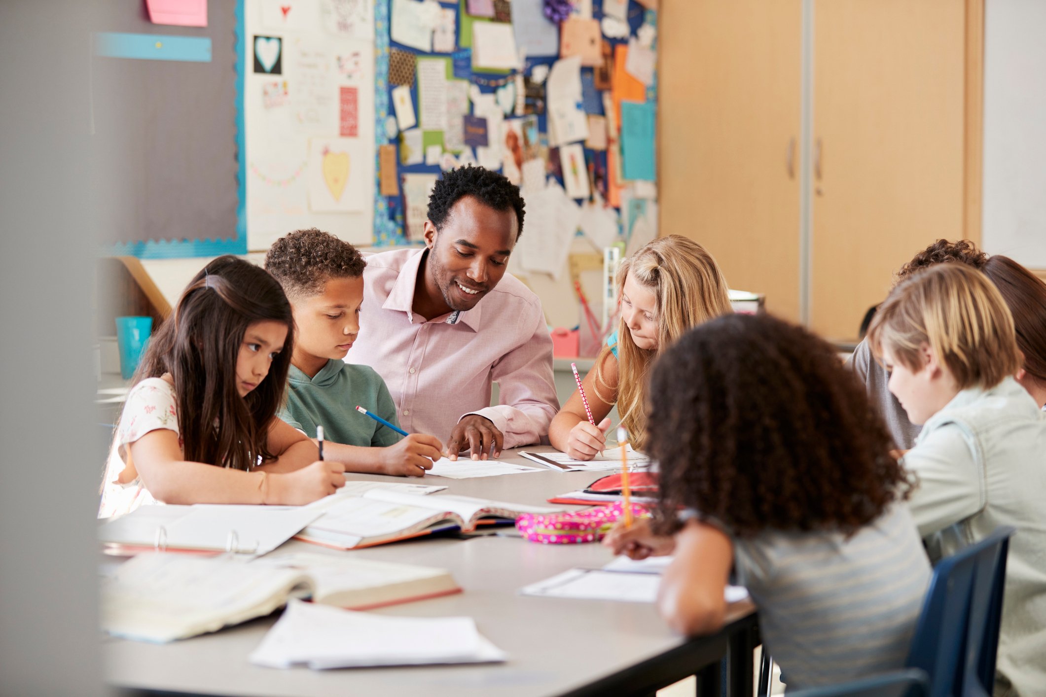Teacher helping young student during a hands-on classroom activity