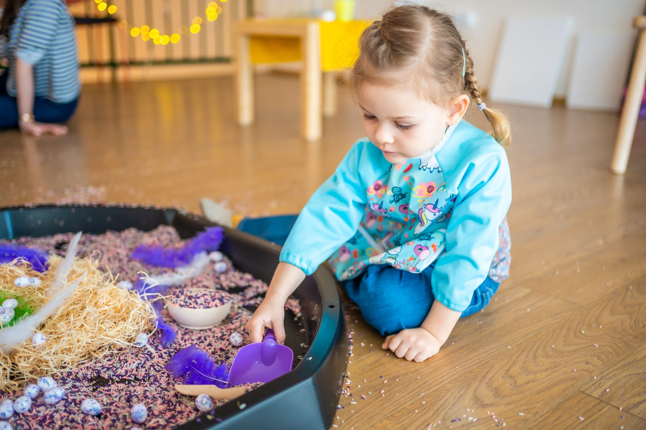 Little girl playing in a sensory bin