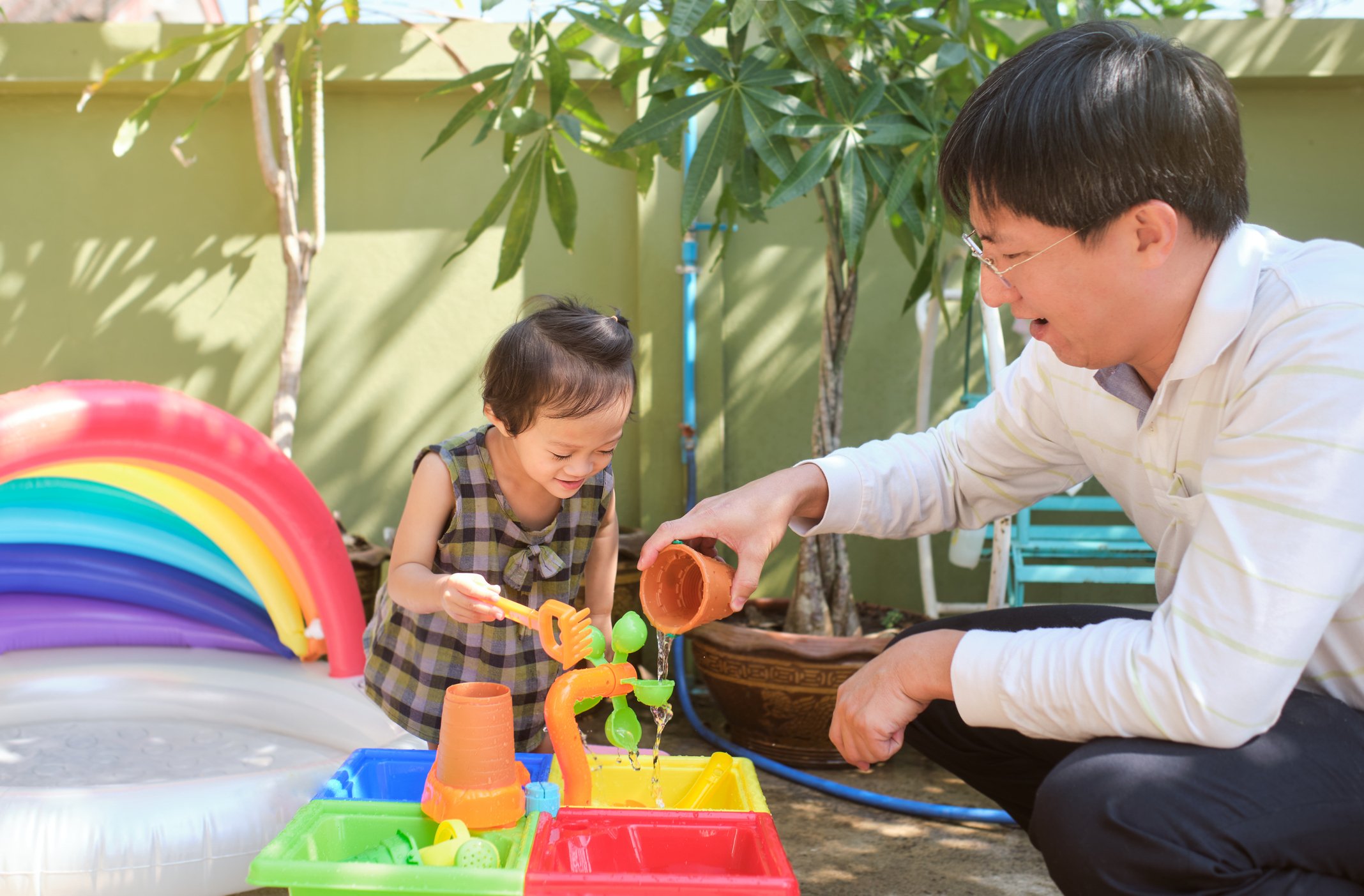 Parent and child playing at a safe sensory table with sand and water.
