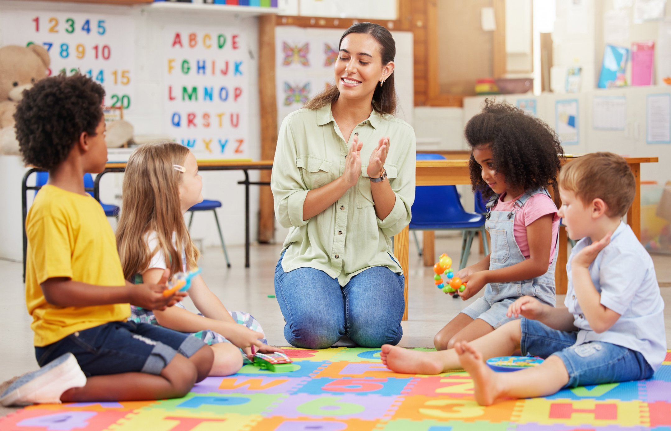 Childcare provider teaching young children in a grant-funded preschool.