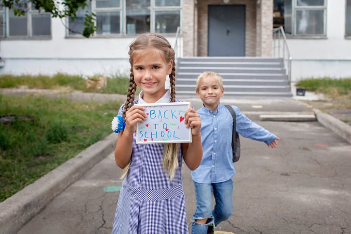 Young girl holding a back to school sign