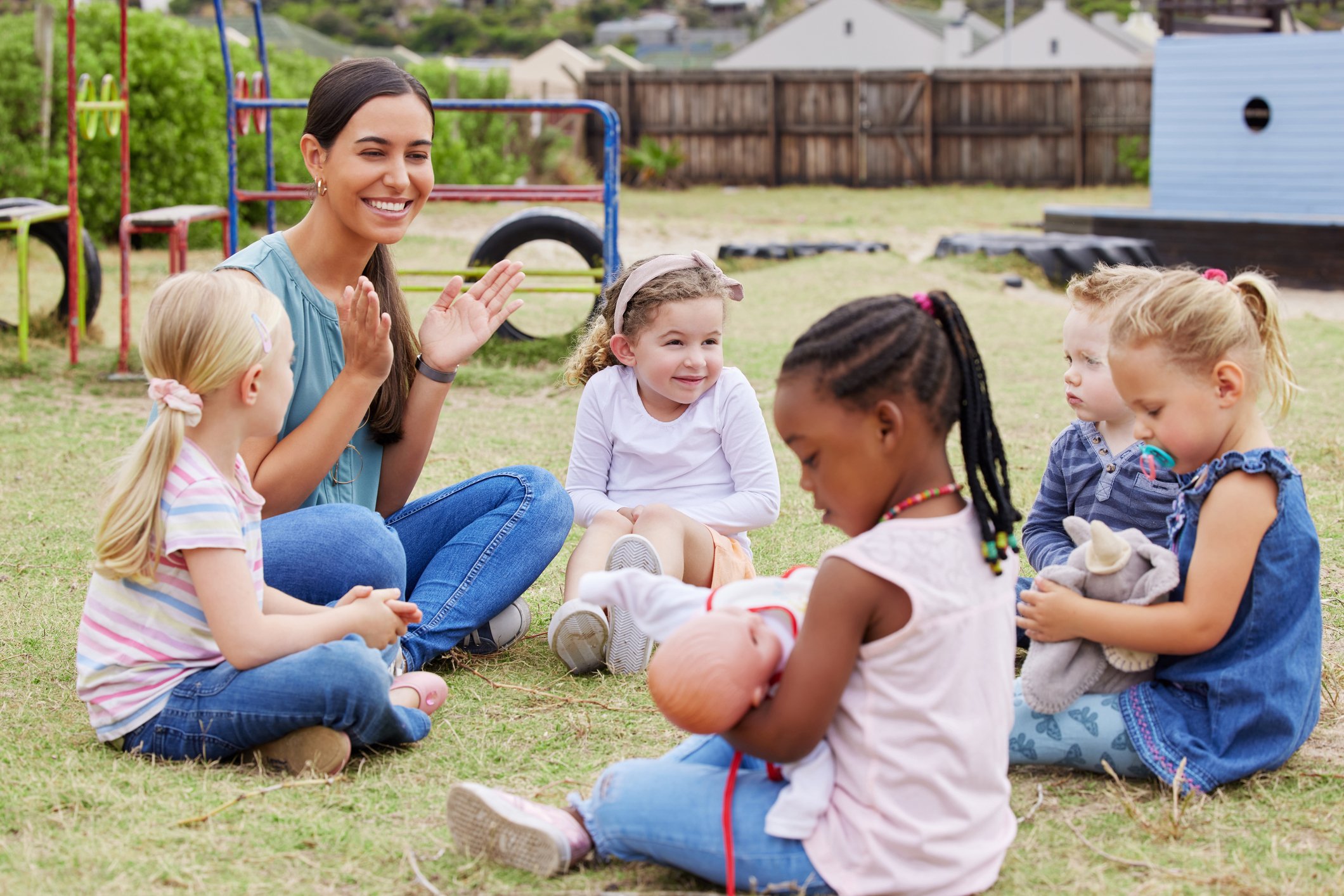 Teacher engaging a diverse group of children in an outdoor activity as part of a CCDBG-supported childcare program