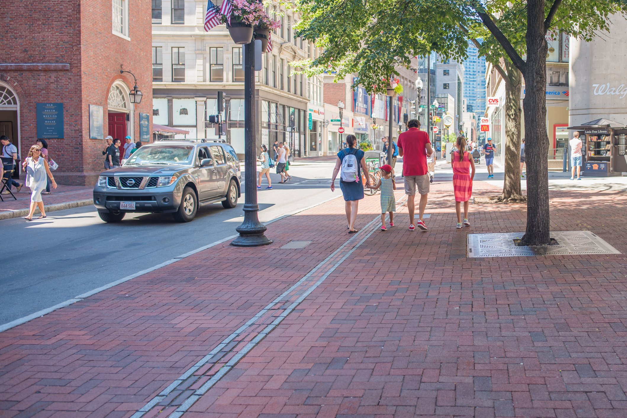 Family walking together on sidewalk