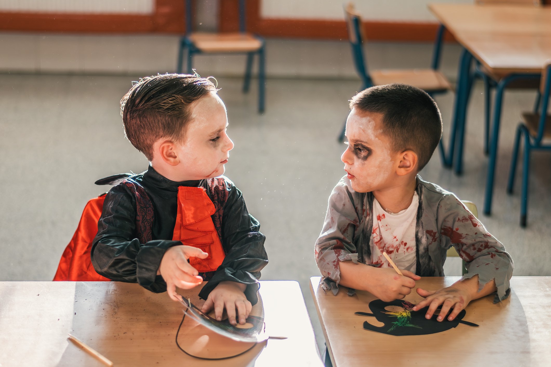 Children in Halloween costumes painting